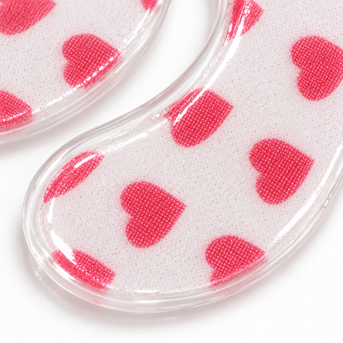 Close-up texture of Sweet Heart printed nonwoven hydrogel eye patches with pink heart pattern